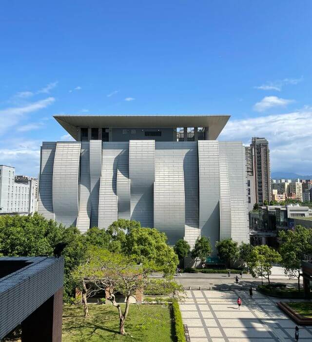 NTPU Library, the iconic building at National Taipei University. The Master Program in Smart Healthcare Management is located at the College of Social Science Building, the left side of the library. On a sunny day at about 3-5pm, there will be geometric shape of shadows on the wall. You can see the view through the window from the program office.